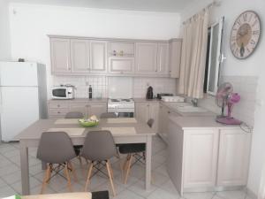 a kitchen with white cabinets and a table and chairs at Antonello House in Lixouri +10 photos