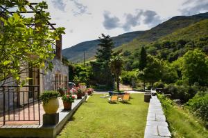 a house with a garden with mountains in the background at Vitali River House Andros in Andros