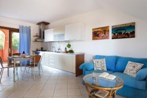 a living room with a blue couch and a kitchen at Granito's in Monte Petrosu
