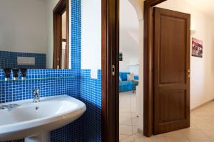 a bathroom with a white sink and blue tiles at Granito's in Monte Petrosu