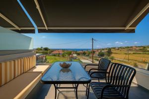 a table and chairs on a balcony with a view at Sunset View House In Chalkidiki in Nea Potidaea