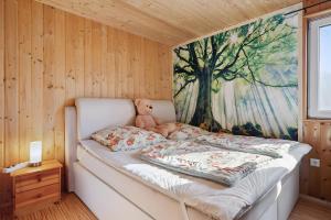 a teddy bear sitting on a bed in a room at Ferienhaus 249 - Haus Seeblick in Zadelsdorf
