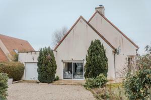 a white house with two trees in front of it at Chambre Armand in Louvigny
