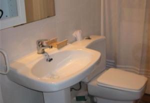 a bathroom with a white sink and a toilet at Baywatch Penthouse in Altafulla +9 photos