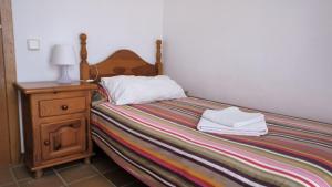 a bedroom with a bed and a night stand with a lamp at Baywatch Penthouse in Altafulla