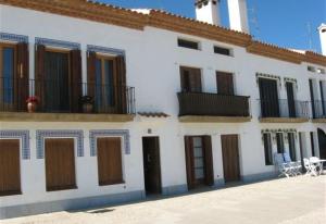 a white building with brown doors and windows at Baywatch Penthouse in Altafulla