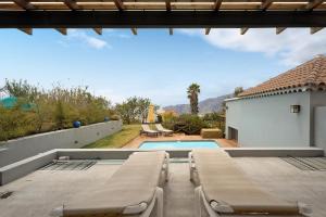 a swimming pool with two chaise lounges next to a house at Casa La Plaza in El Paso