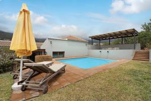a backyard with a pool and an umbrella and a chair at Casa La Plaza in El Paso