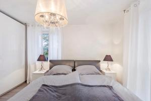 a bedroom with a bed with two lamps and a chandelier at Helgas Horizon in Rottweil