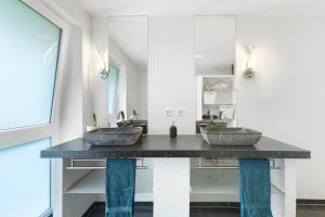 two sinks in a bathroom with a large mirror at Helgas Horizon in Rottweil +19 photos