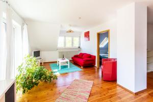 a living room with a red couch and a table at Elstar in Stockach +2 photos