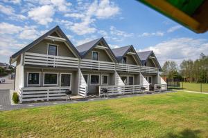 a large house with a gambrel roof at Domki u Bazyla in Sarbinowo +15 photos