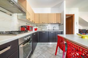 a kitchen with a counter and red chairs in it at Casa Annabella in Sarroch +15 photos