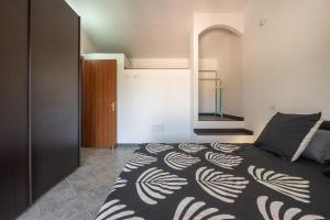 a bedroom with a bed with a black and white blanket at Casa Annabella in Sarroch