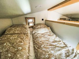 a large bed in a small room in a trailer at Holiday Home Tiny Haus Glockenalm-Haus zum Glück by Interhome in Aurach +16 photos