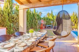 a patio with a table with chairs and a swing at Serra Fuster - Casa Tolleric in Llucmajor