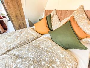 a bed with colorful pillows on top of it at Holiday Home Tiny Haus Glockenalm- Haus MaRe by Interhome in Aurach