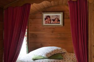 a bedroom with a bed and a picture of two babies at Roulotte De Cabrières in Compeyre