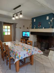 a dining room with a table and a tv at Maison Typique De Montagne in Ercé