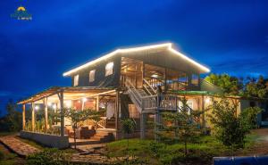 a house lit up at night with lights at Equator Lodge & Campsite in Kikorongo
