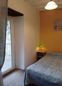 a bedroom with a bed and a sliding glass door at Maison Typique De Montagne in Ercé