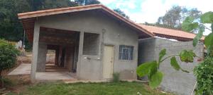 a small house with a door in a yard at Espaço LIMÃO CRAVO in Sapucaí-Mirim