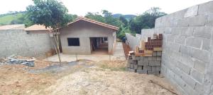 a house under construction with a pile of bricks at Espaço LIMÃO CRAVO in Sapucaí-Mirim