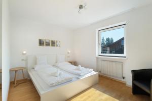 a white bed in a room with a window at Premium App Hofer Monika in Villabassa