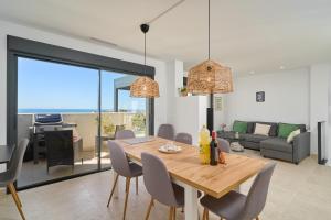 a dining room and living room with a table and chairs at Exclusive Getaway – Ocean View in Torrox Costa