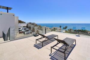 a patio with two chairs and a table on a building at Exclusive Getaway – Ocean View in Torrox Costa