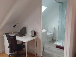 a desk with a computer and a chair in a room at Chambre D'hôtes Lesseps in Vendôme