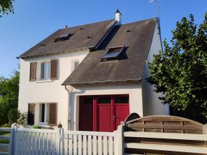a house with red doors and a white fence at Chambre D'hôtes Lesseps in Vendôme