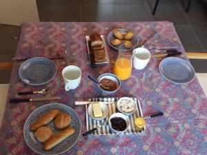 a table topped with plates of breakfast foods and orange juice at Chambre D'hôtes Lesseps in Vendôme