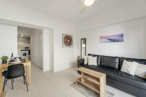 a living room with a black couch and a table at Charming one bedroom Los Cristianos in Arona