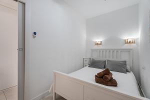 a white bedroom with a bed with towels on it at Charming one bedroom Los Cristianos in Arona