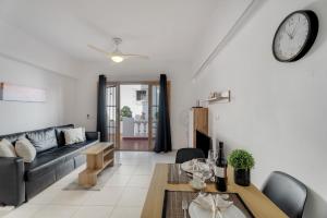 a living room with a couch and a clock on the wall at Charming one bedroom Los Cristianos in Arona