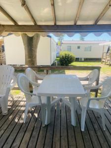 a white table and chairs on a deck at Camping Canet plage mobilhome 4 ou 6 personnes in Canet-en-Roussillon