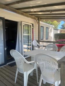 a white table and chairs on a deck at Camping Canet plage mobilhome 4 ou 6 personnes in Canet-en-Roussillon +45 photos