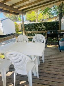 a white table and chairs on a wooden deck at Camping Canet plage mobilhome 4 ou 6 personnes in Canet-en-Roussillon