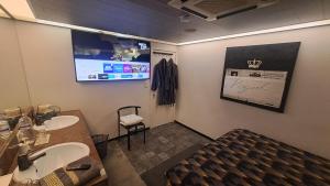 a bathroom with a sink and a tv on the wall at BeautyD GREY ROOM centrum GULLEGEM KORTRIJK in Wevelgem