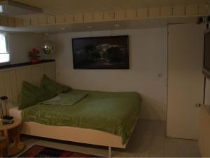 a bedroom with a bed with a green comforter at Gästezimmer Jülich mit Küche in Weil am Rhein
