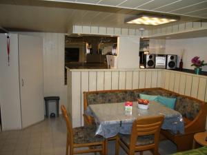 a dining room with a table and chairs and a kitchen at Gästezimmer Jülich mit Küche in Weil am Rhein