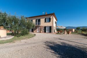 a large house on a gravel road in front at Casa del Nonno Bingheri in Cortona