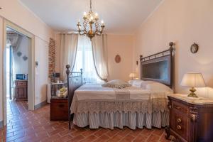 a bedroom with a large bed and a chandelier at Casa del Nonno Bingheri in Cortona