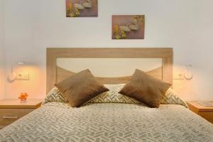 a bedroom with a bed with two pillows on it at Arinaga Home in Arinaga
