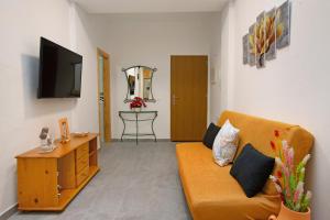 a living room with a couch and a tv at Arinaga Home in Arinaga
