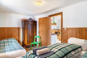 a bedroom with a bed and a green chair at Sonnenhütte Wildschönau Obergeschoß in Grafenweg