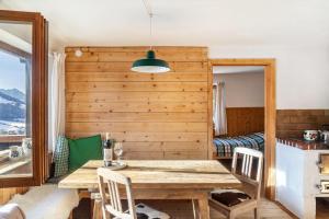 a dining room with a wooden table and a bed at Sonnenhütte Wildschönau Obergeschoß in Grafenweg +15 photos