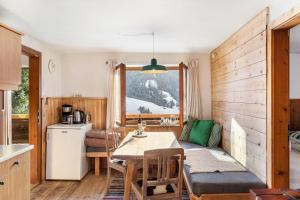 a kitchen and a dining room with a table and a window at Sonnenhütte Wildschönau Obergeschoß in Grafenweg