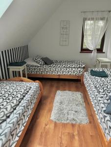 a room with three beds and a rug on the floor at Mazurska Oaza in Pisz